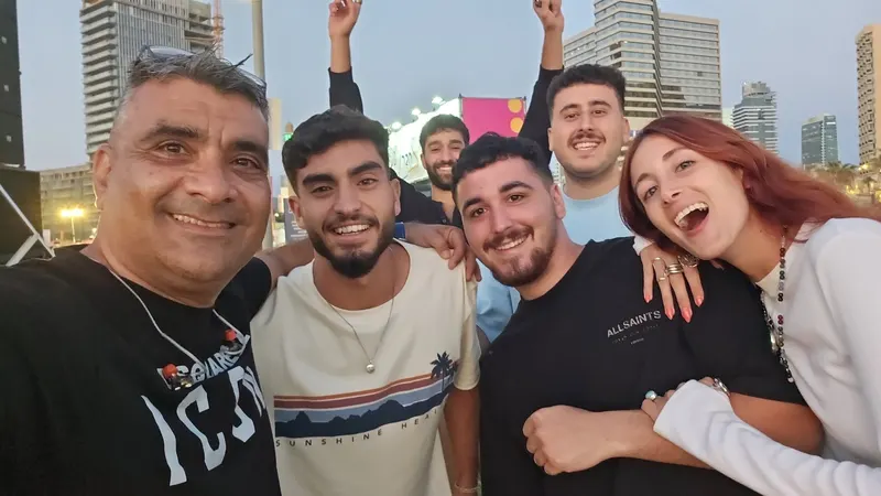 סלפי של חבר להקה עם קהל צעיר ושמח באירוע חוצות